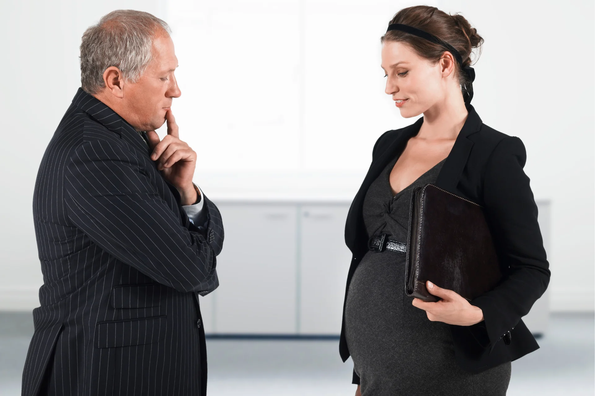 Male boss discriminating pregnant woman at work