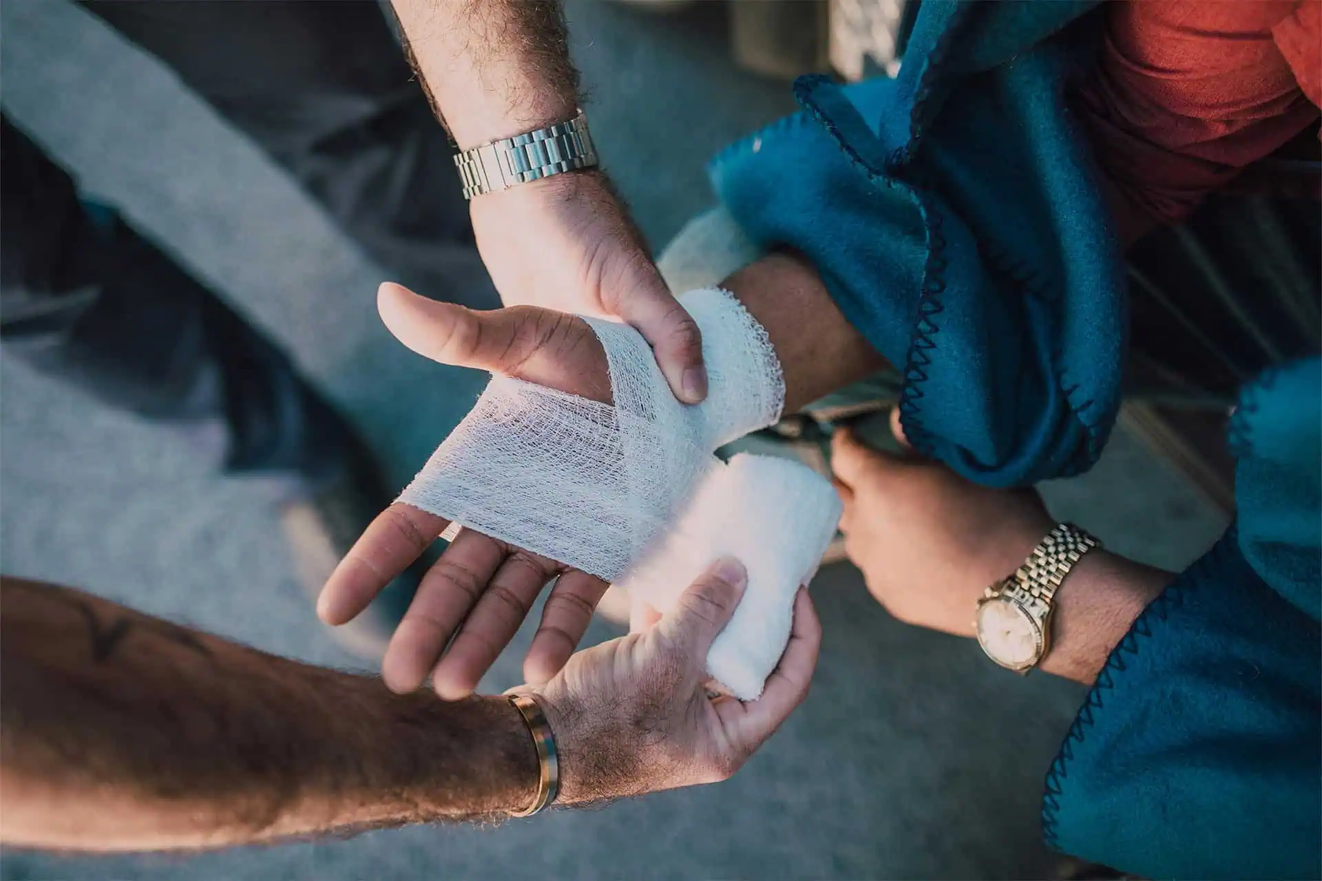 People bandaging an injured individual